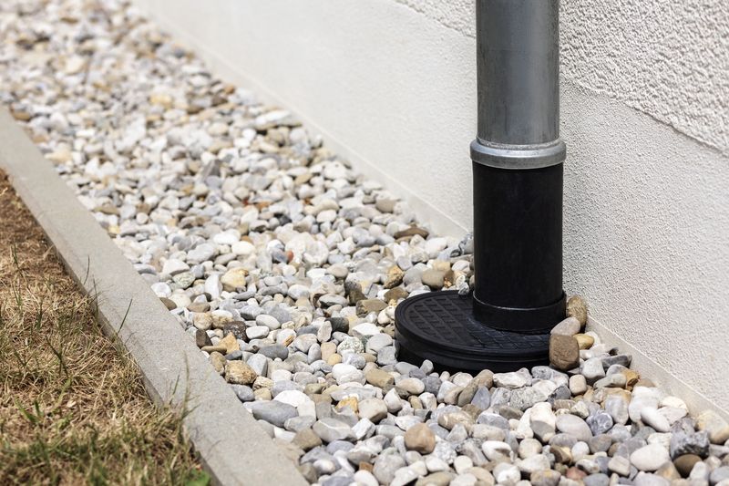 Gutter downspout connected to an underground drain pipe