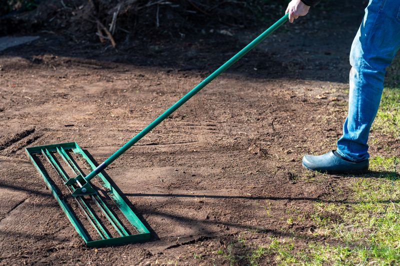 Leveling rake smoothing soil while regrading a yard